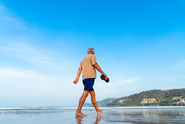 Un hombre mayor caminando por la playa